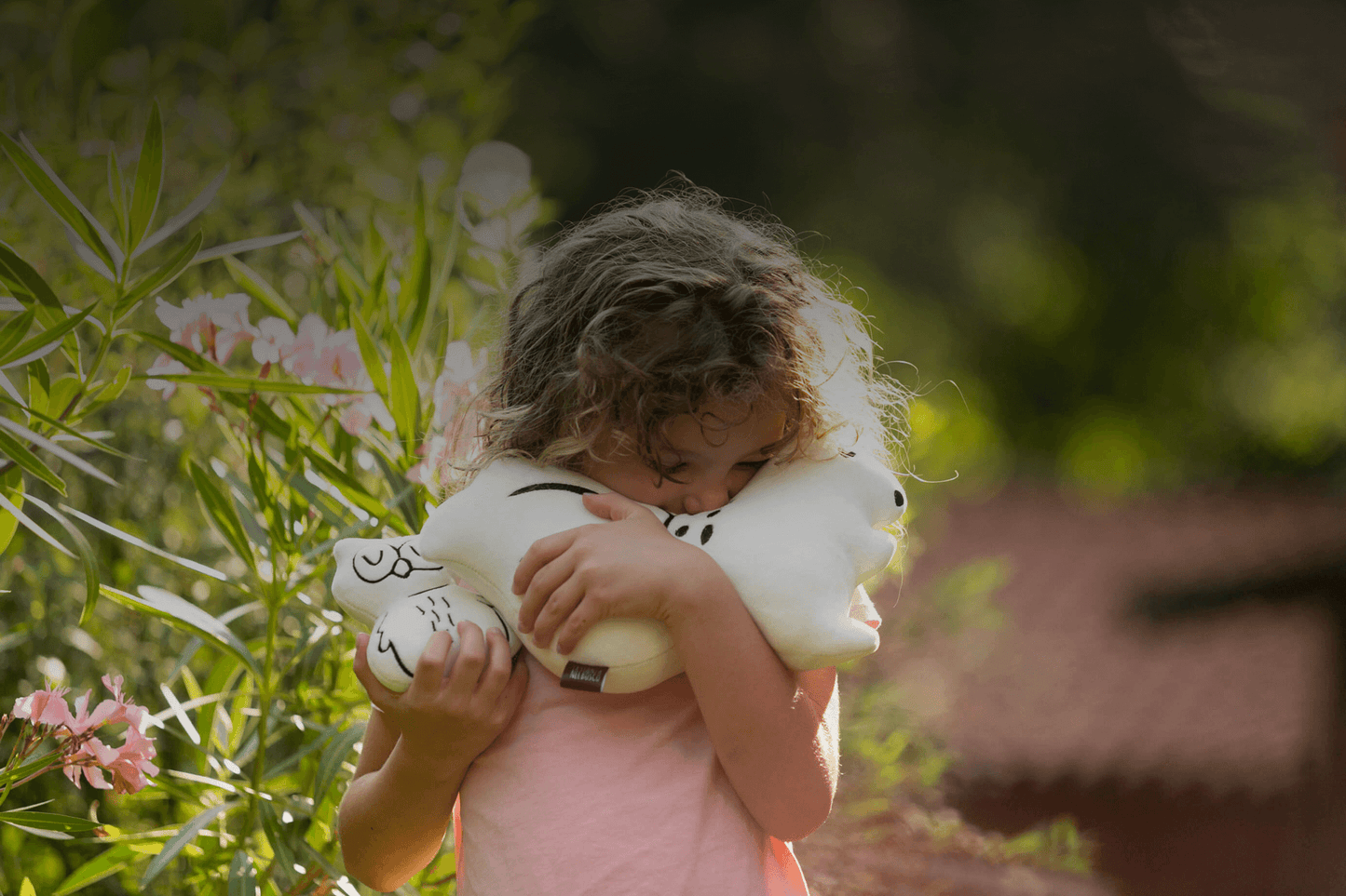 bambina felice che abbraccia un cuscino a forma di scoiattolo